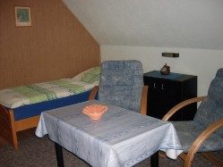 Gemütliches Wohn/Schlaf mit Bett, Tisch und zwei Stühlen. Gemütliches Wohn/Schlaf mit Bett, Tisch und zwei Stühlen.